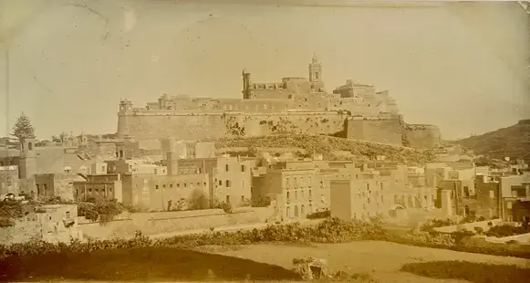 The Cittadella rising above Victoria, photographed by Mikiel Farrugia around 1910. Public domain.