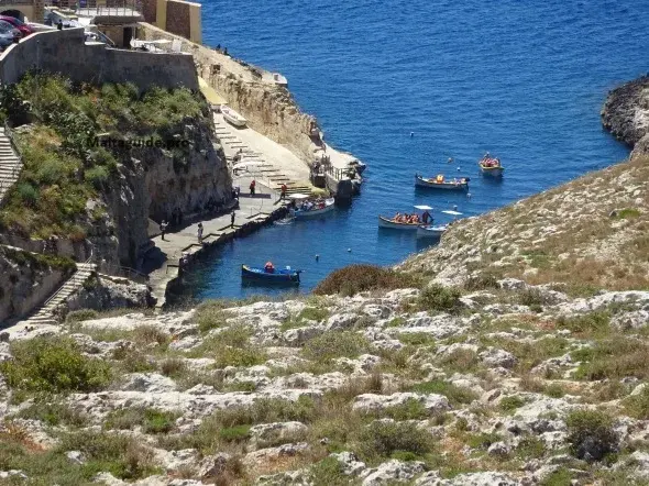 Small local boats leave Wied iż-Żurrieq for the weather-dependent trip through the Blue Grotto sea caves.