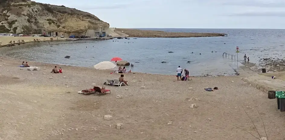 The beach nearby: Waterfront restaurants and limestone cliffs around Xlendi Bay Gozo.